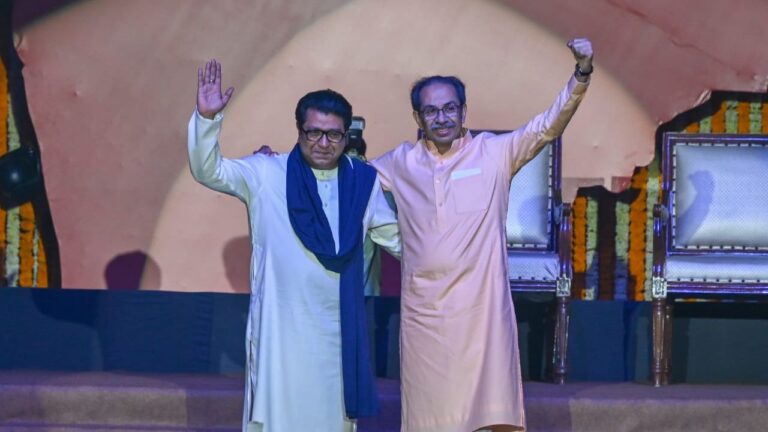 उद्धव ठाकरे और राज ठाकरे मंच पर गले मिलते हुए