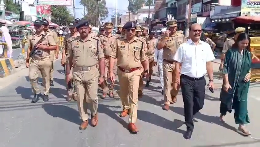 Police officers marching with crowd awareness in Muzaffarnagar